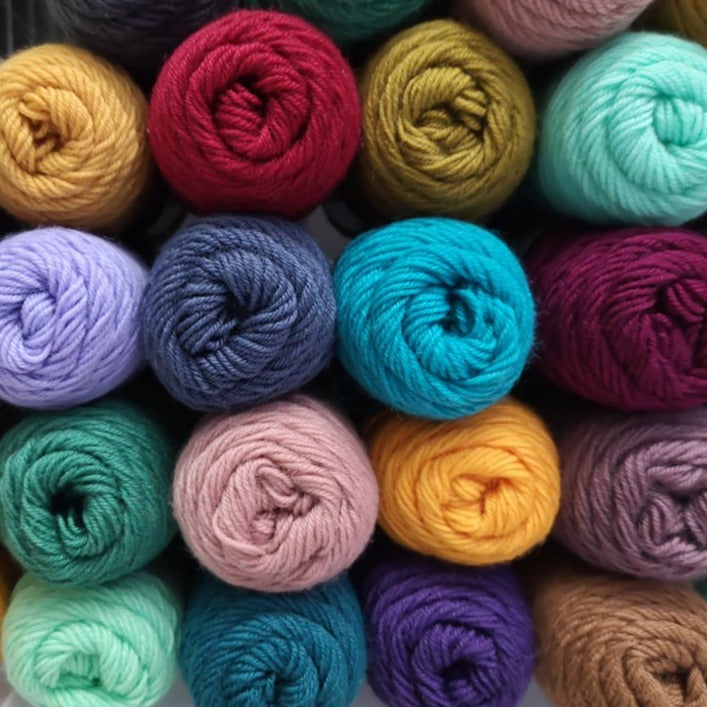 A colourful close up of Lang Yarns Jawoll Superwash sock yarn piled up in different colours